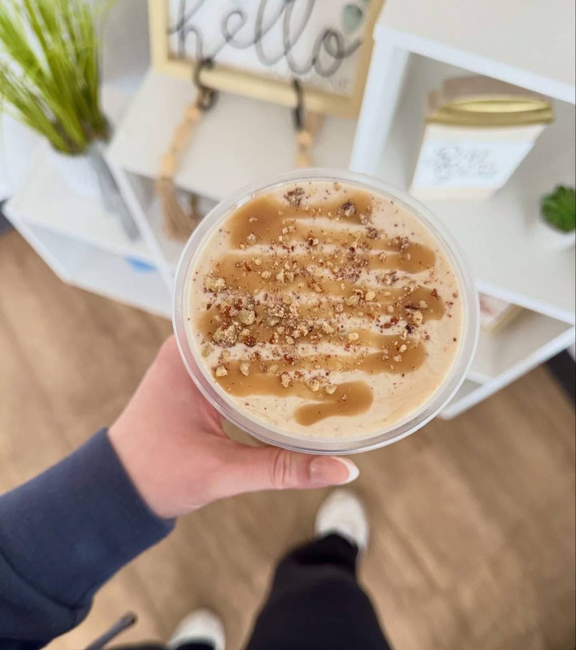 Overhead view of a caramel-drizzled shake topped with candied pecan crumble