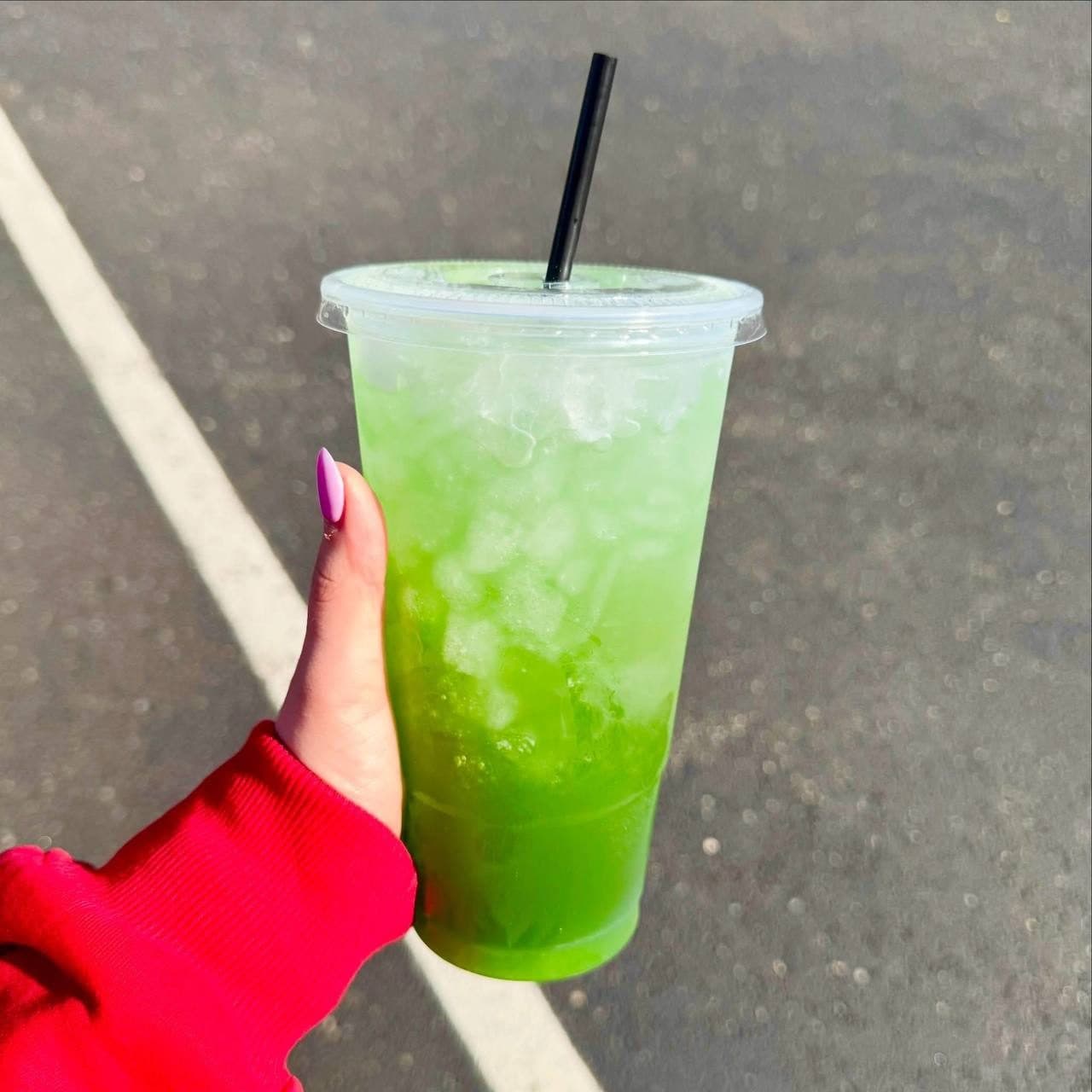 A green ombre loaded tea held up outside Spartans Nutrition